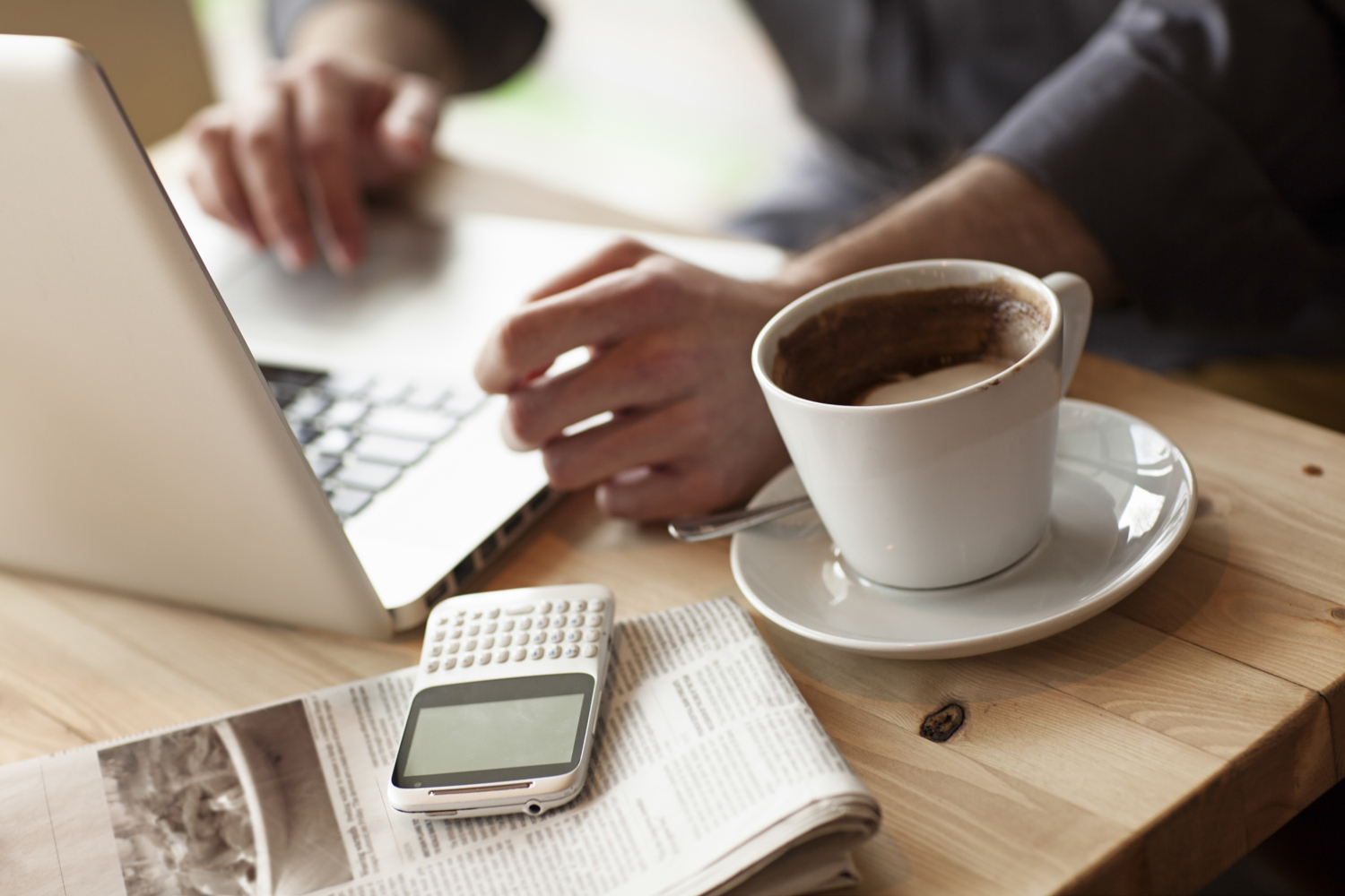 stock-photo-close-up-of-man-using-laptop-with-cup-of-coffee-in-cafe-97119431
