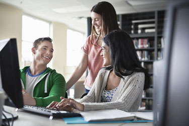 A group of DBS students working at a computer