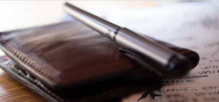 A pen on top of a brown wallet