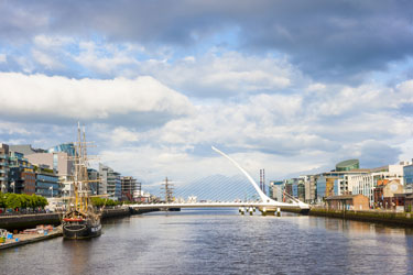 Dublin's white Samuel Beckett bridge over a river with buildings on either side