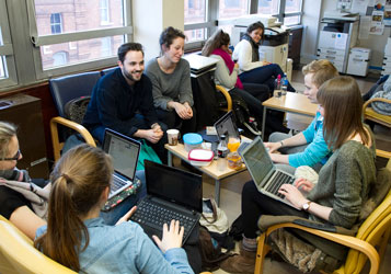 A group of students sitting together working on laptops